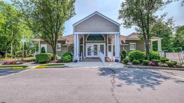 a view of a house with a yard and potted plants