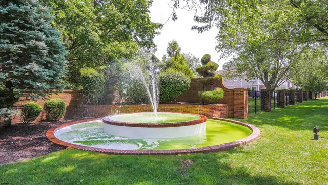a view of a fountain in the front of a house with a fountain
