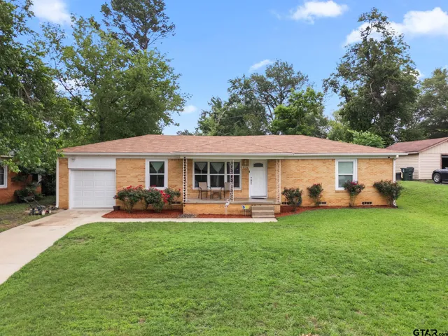 a front view of a house with a garden and patio