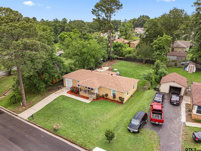 an aerial view of a house with backyard garden and outdoor seating