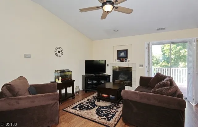 a living room with furniture a fireplace and a flat screen tv