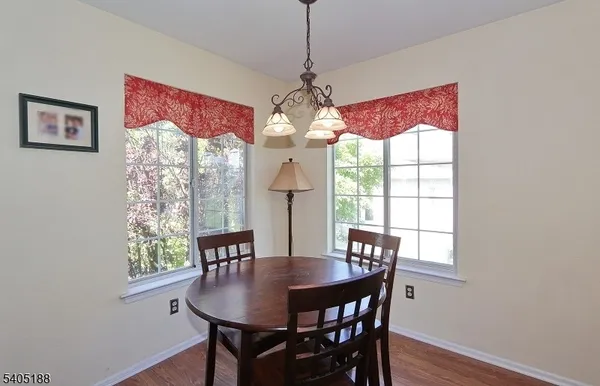 a dining room with furniture a chandelier and wooden floor