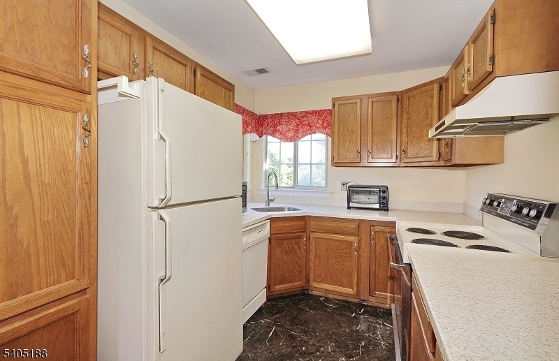 58 Wescott Road Bedminster, NJ 07921 - Photo 4 of 13 a kitchen with stainless steel appliances granite countertop a refrigerator a sink dishwasher a stove with white cabinets and wooden floor