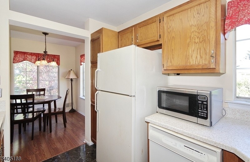 58 Wescott Road Bedminster, NJ 07921 - Photo 6 of 13 a white kitchen with wooden floors and stainless steel appliances