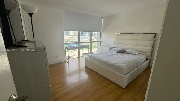 a bedroom with a bed window and a flat screen tv