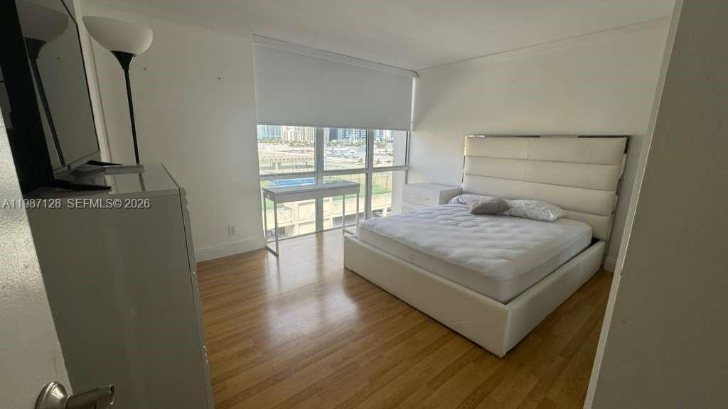 16909 North Bay Road, Unit 710 Sunny Isles Beach, FL 33160 - Photo 12 of 19 a bedroom with a bed window and a flat screen tv