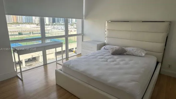 a bedroom with a large bed and a large window