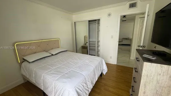 a bedroom with a bed and a flat screen tv