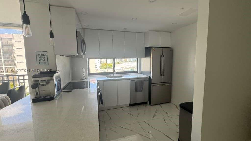 16909 North Bay Road, Unit 710 Sunny Isles Beach, FL 33160 - Photo 6 of 19 a kitchen with a refrigerator and a sink