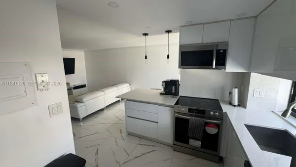 a kitchen with stainless steel appliances a stove a microwave and a refrigerator