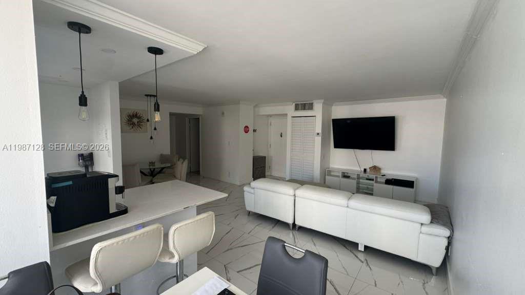 16909 North Bay Road, Unit 710 Sunny Isles Beach, FL 33160 - Photo 10 of 19 a living room with furniture and a flat screen tv