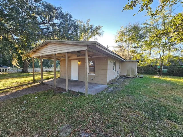 a view of a house with backyard and sitting area