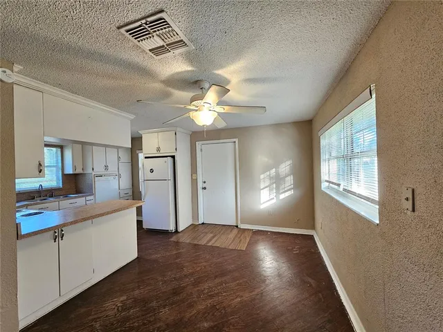 a view of a kitchen cabinets a chandelier fan and wooden floor