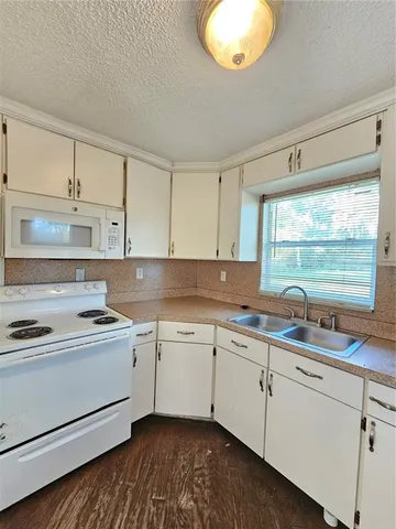 a kitchen with a sink stove and cabinets