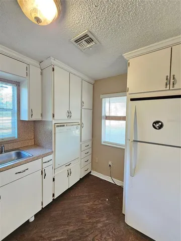a kitchen with white cabinets and white appliances