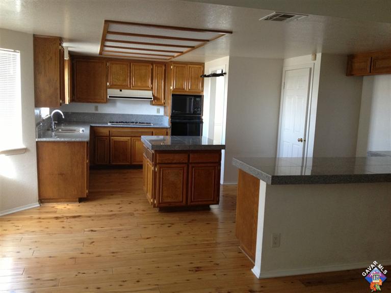 5115 Claro Way Palmdale, CA 93551 - Photo 3 of 7 a kitchen with stainless steel appliances granite countertop a sink and a refrigerator