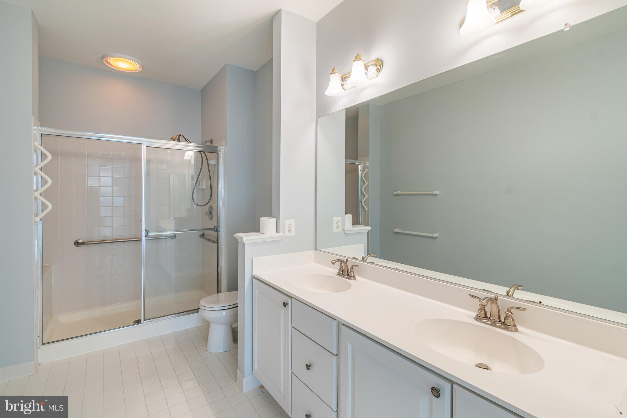 314 Colony Point Place Edgewater, MD 21037 - Photo 27 of 31 a bathroom with a double vanity sink toilet and shower