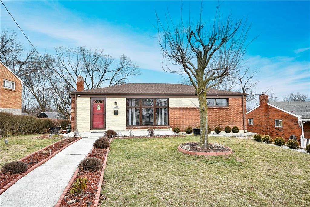 a front view of a house with a yard outdoor seating and covered with trees