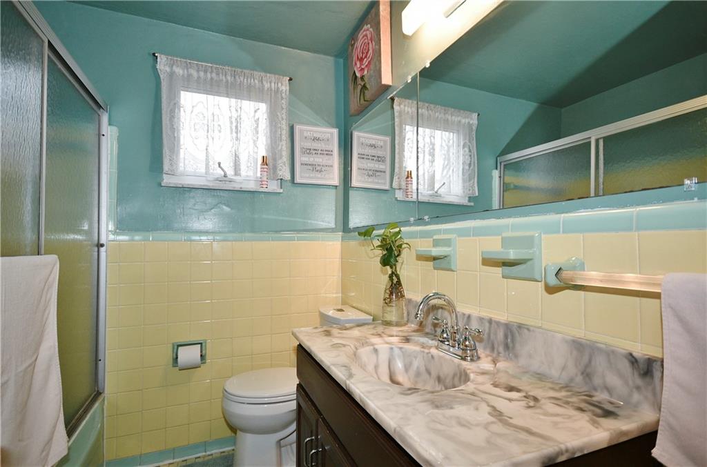 1619 Hollyrood Road Pittsburgh, PA 15227 - Photo 16 of 25 a bathroom with a granite countertop sink a toilet and a mirror