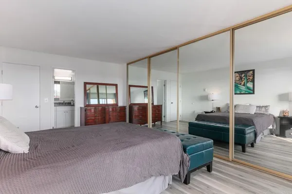 a bedroom with a bed and painting on the wall