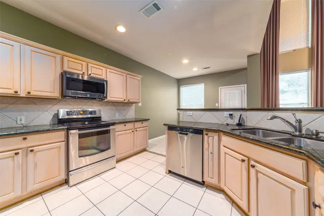 a kitchen with stainless steel appliances granite countertop a stove sink and cabinets