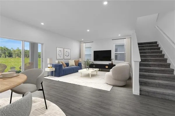 a living room with furniture a flat screen tv and a large window