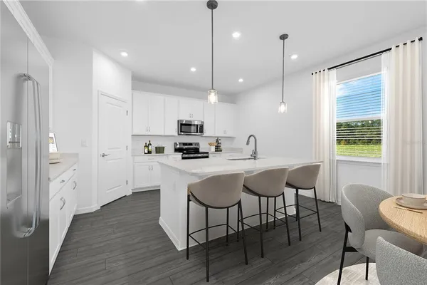 a kitchen with stainless steel appliances granite countertop a kitchen island hardwood floor and a sink