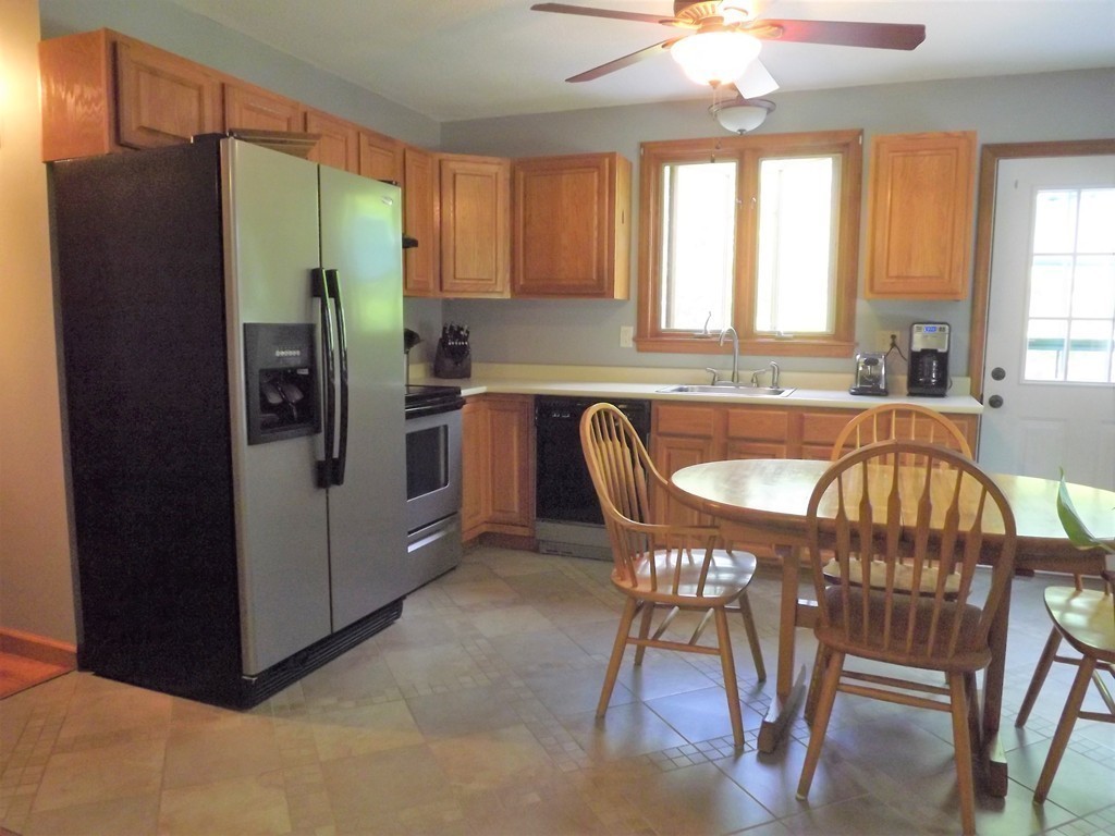 343 Cedar Swamp Road Monson, MA 01057 - Photo 6 of 24 a kitchen with stainless steel appliances granite countertop a refrigerator a stove a sink a dining table and chairs with wooden floor