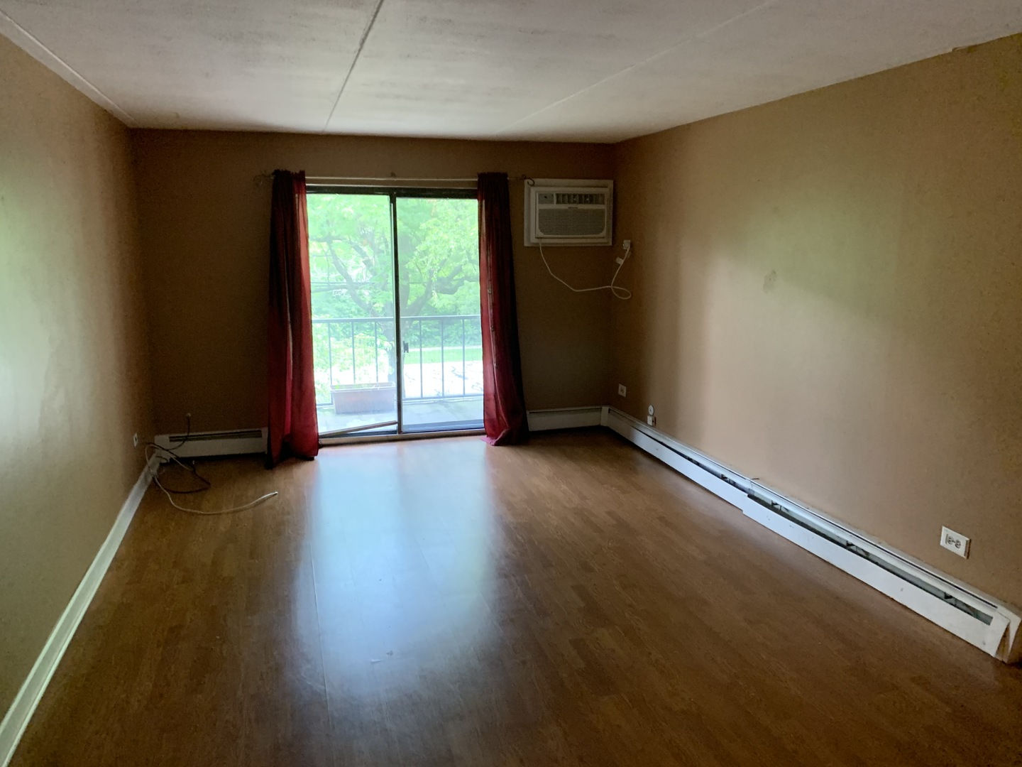528 East Bailey Road, Unit 102 Naperville, IL 60565 - Photo 3 of 8 an empty room with wooden floor and windows with curtains