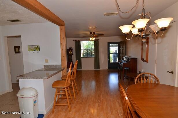 6324 Anvil Road Jacksonville, FL 32277 - Photo 11 of 34 a view of a dining room with furniture wooden floor and chandelier