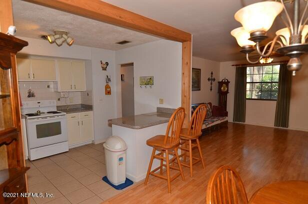 6324 Anvil Road Jacksonville, FL 32277 - Photo 12 of 34 a kitchen with a table chairs stove and wooden floor