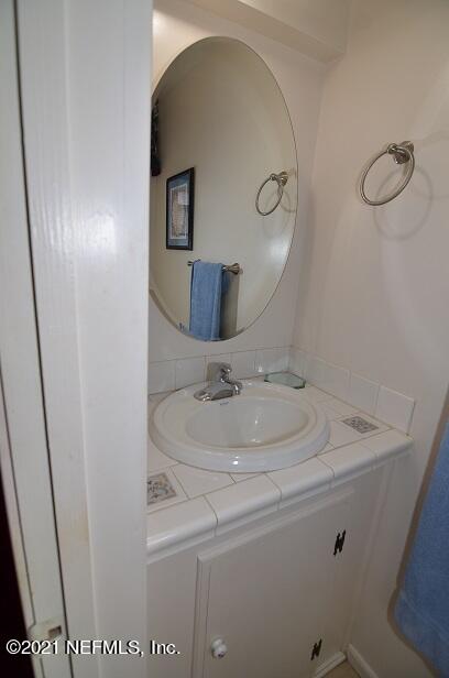 6324 Anvil Road Jacksonville, FL 32277 - Photo 23 of 34 a bathroom with a sink and mirror
