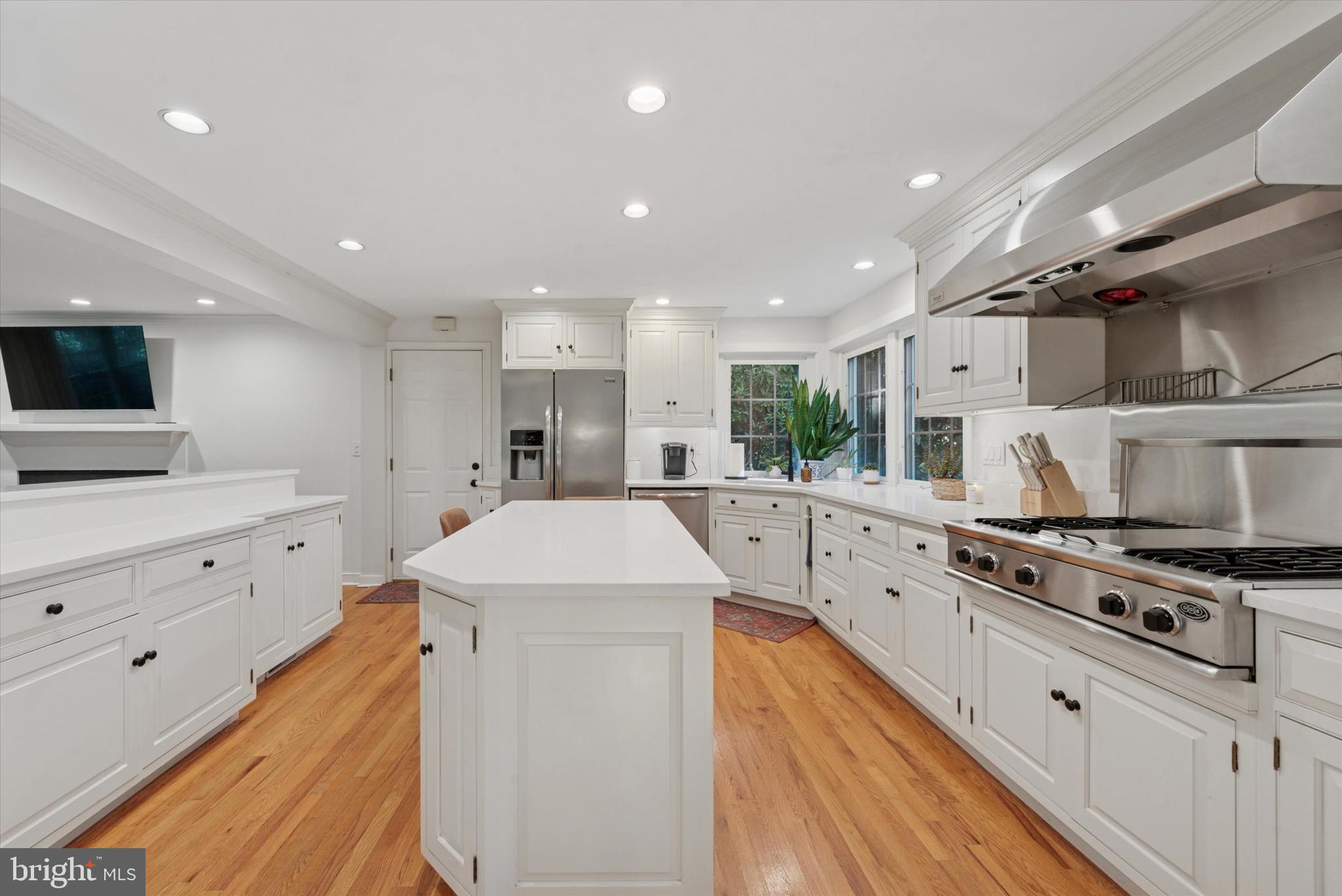 103 Deepdale Road Wayne, PA 19087 - Photo 9 of 41 a kitchen with stainless steel appliances kitchen island granite countertop a sink and a stove top oven with wooden floor