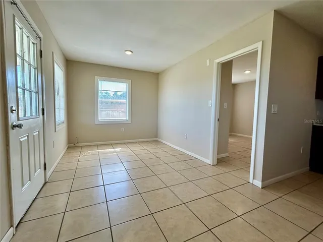 a view of a livingroom with a window and brick walls