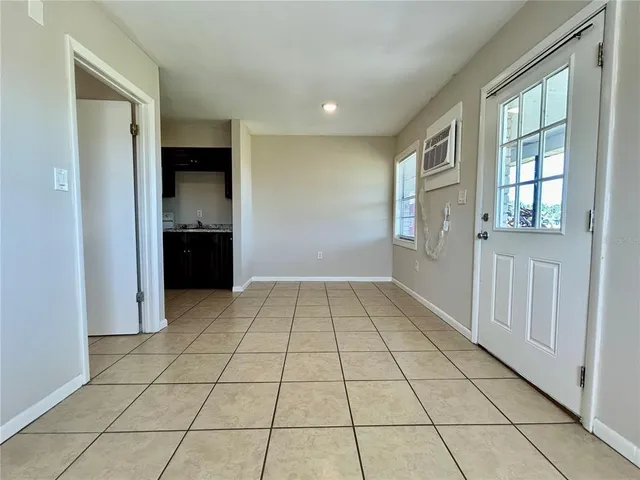 a view of a livingroom with kitchen and windows
