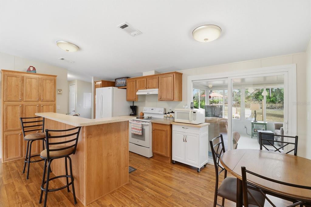 7305 South Threshold Point Homosassa, FL 34446 - Photo 8 of 46 a kitchen with a table chairs refrigerator and microwave