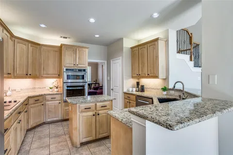 a kitchen with stainless steel appliances granite countertop a sink stove and cabinets