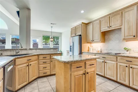 a kitchen with kitchen island granite countertop white cabinets white appliances with a sink and dishwasher
