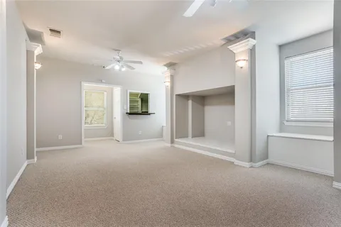 an empty room with windows and cabinet