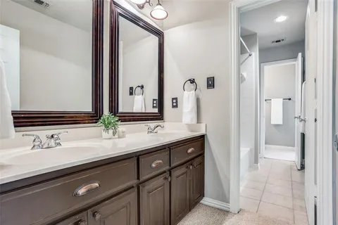 a bathroom with a double vanity sink and a mirror