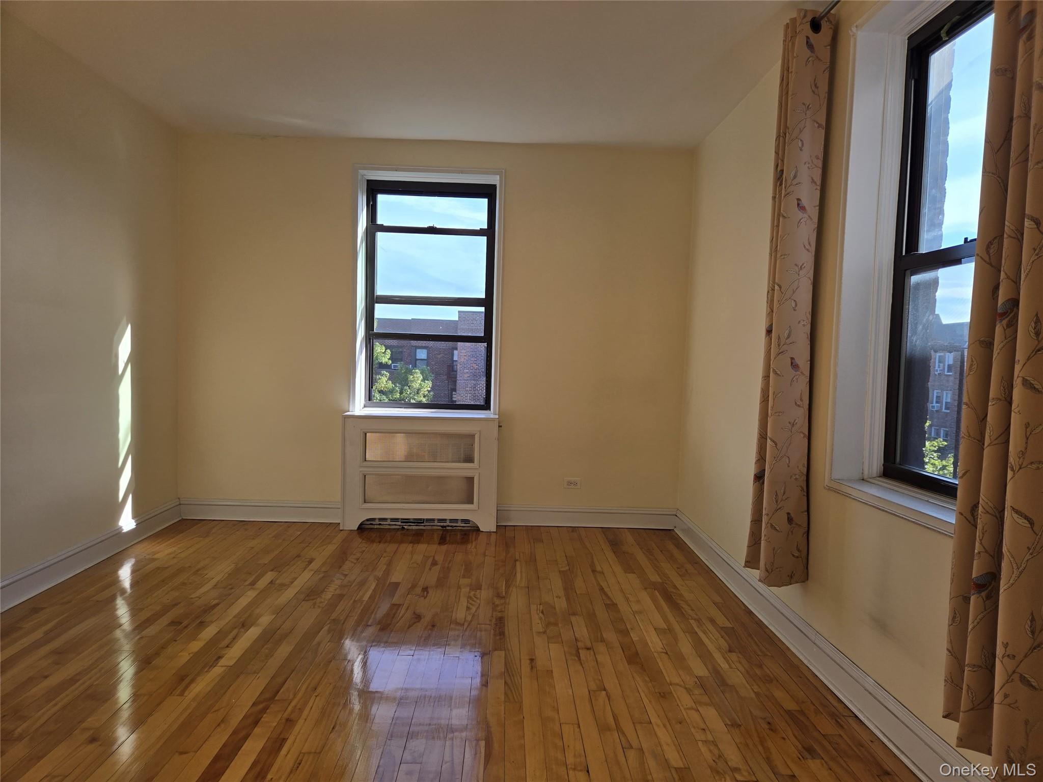 87-09 34th Avenue, Unit 6K Queens, NY 11372 - Photo 11 of 12 a view of a room with wooden floor and a window