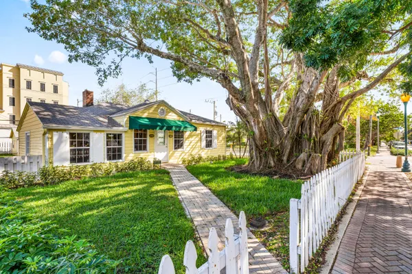 a front view of a house with yard and green space