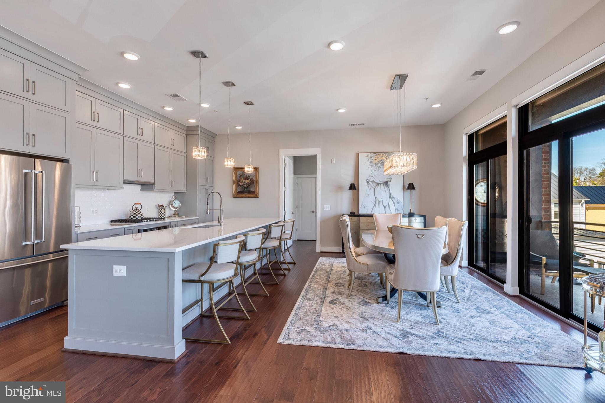 2 Stationmaster Street Southeast, Unit 202 Leesburg, VA 20175 - Photo 11 of 29 a large kitchen with stainless steel appliances granite countertop a table chairs sink and cabinets