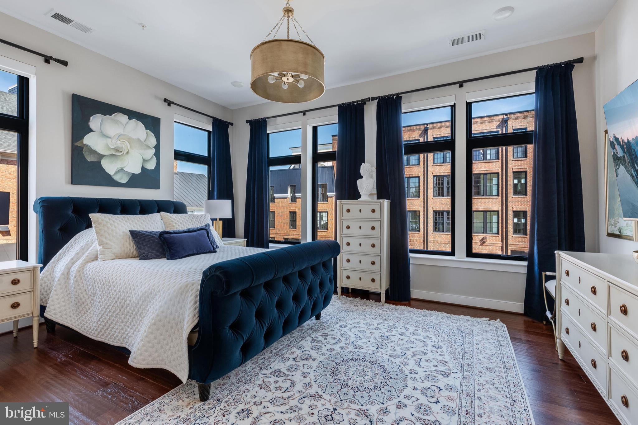 2 Stationmaster Street Southeast, Unit 202 Leesburg, VA 20175 - Photo 19 of 29 a spacious bedroom with a bed and wooden floor