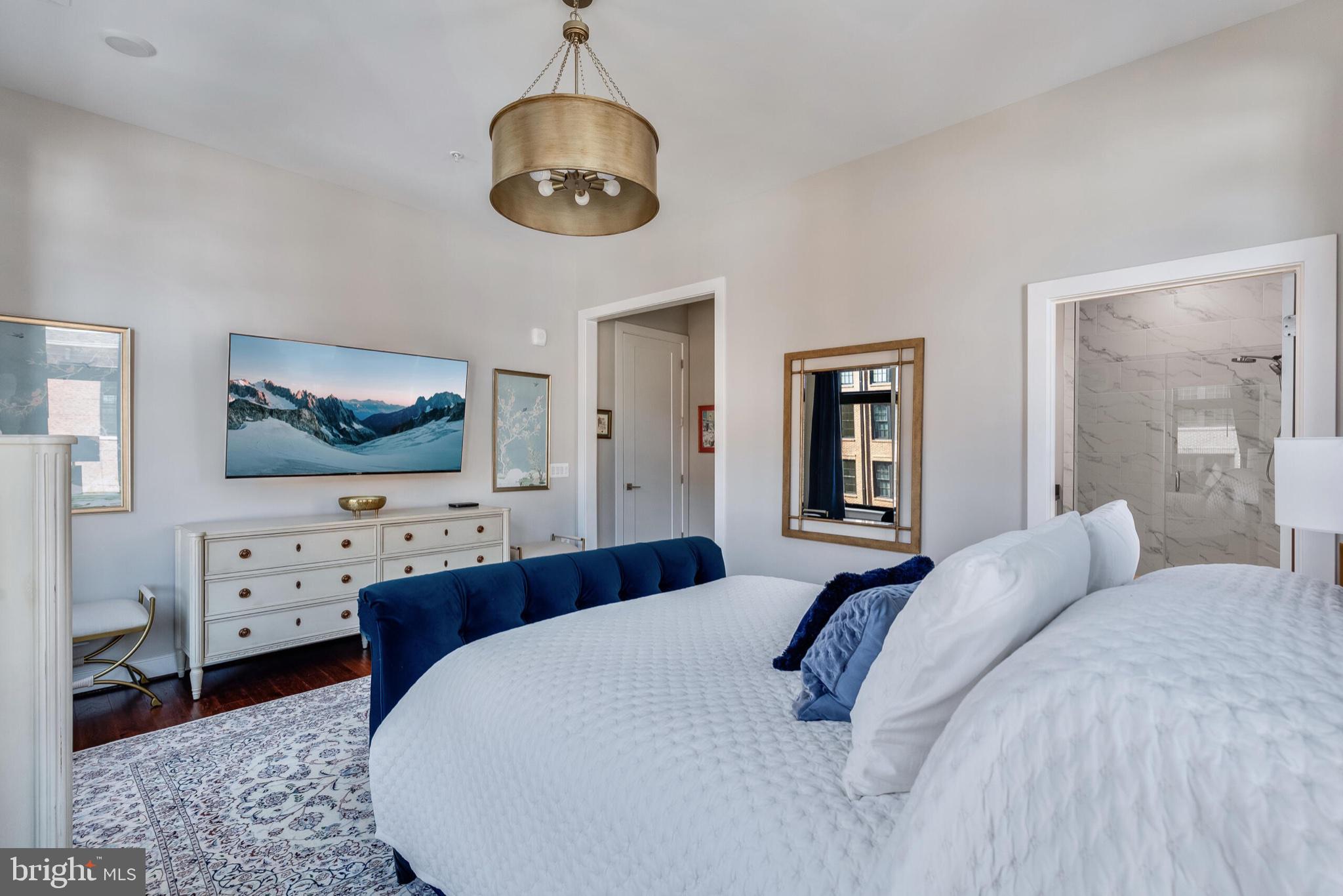2 Stationmaster Street Southeast, Unit 202 Leesburg, VA 20175 - Photo 20 of 29 a spacious bedroom with a large bed and a flat screen tv