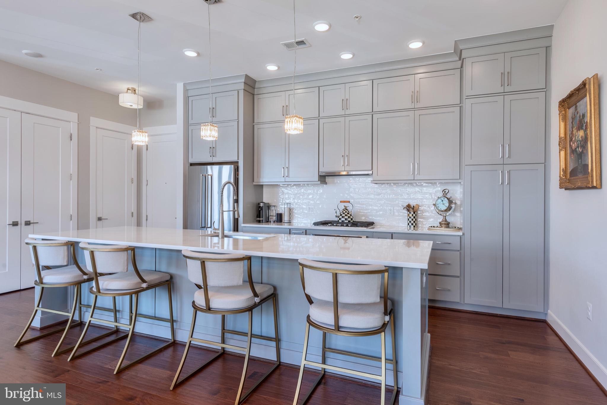 2 Stationmaster Street Southeast, Unit 202 Leesburg, VA 20175 - Photo 3 of 29 a kitchen with stainless steel appliances granite countertop white cabinets and chairs