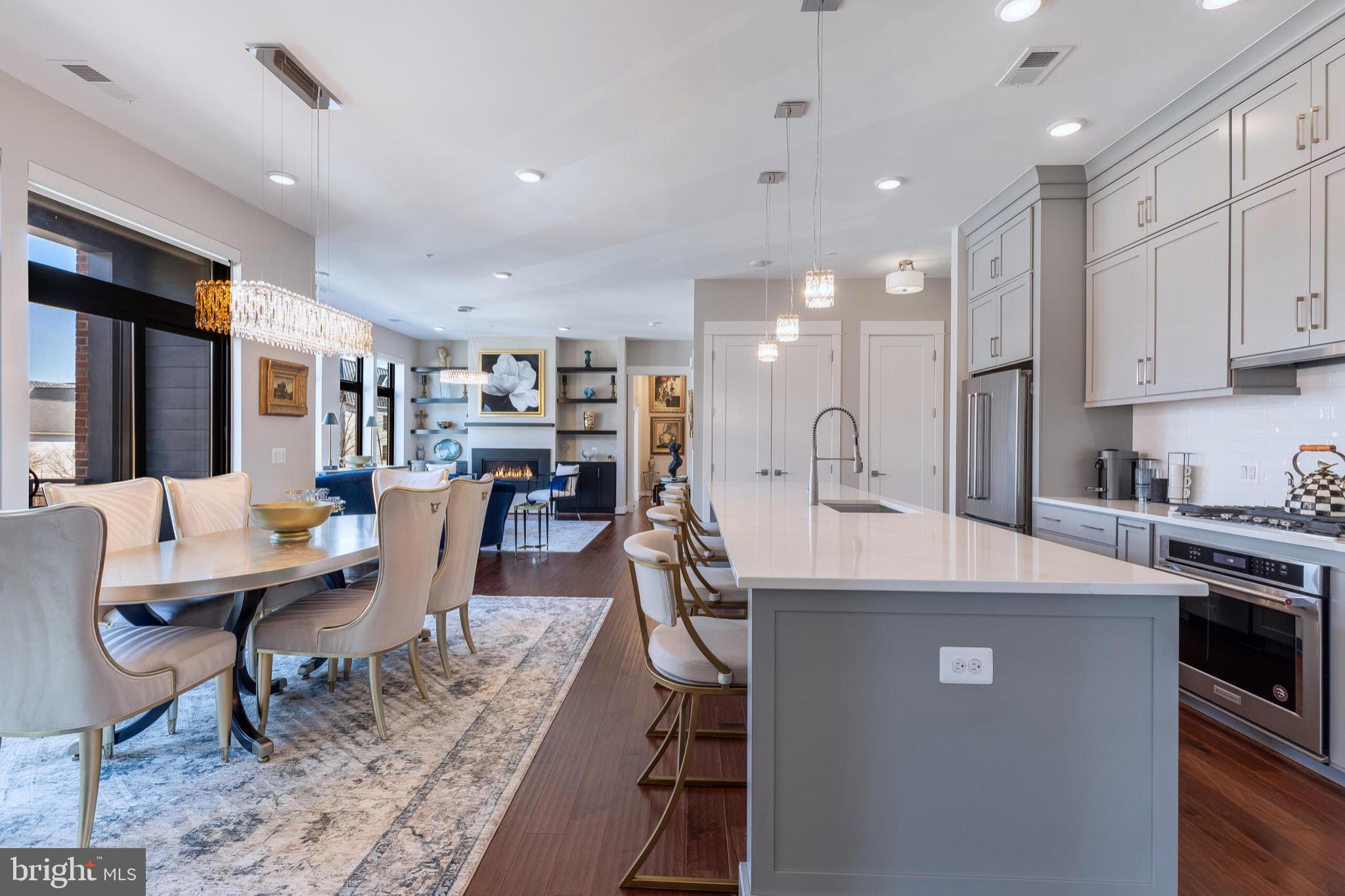 2 Stationmaster Street Southeast, Unit 202 Leesburg, VA 20175 - Photo 10 of 29 a living room with stainless steel appliances kitchen island granite countertop a table chairs and a refrigerator