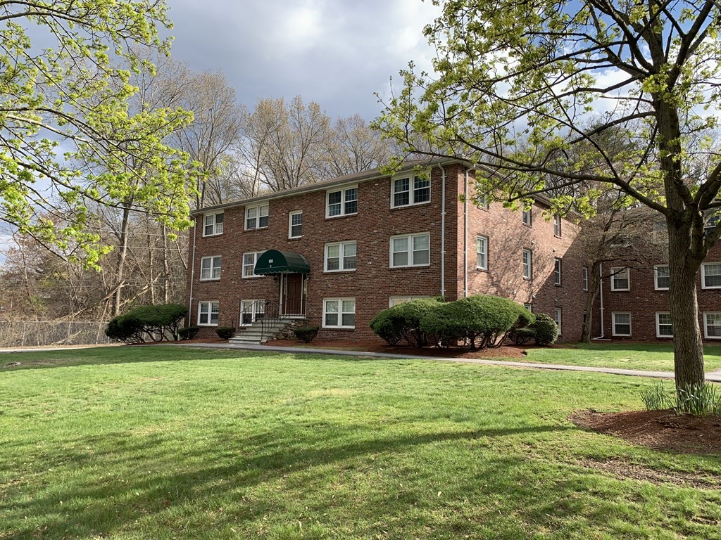 180 Tyngsboro Road, Unit 55D Chelmsford, MA 01863 - Photo 15 of 20 a view of a house with a big yard and large trees