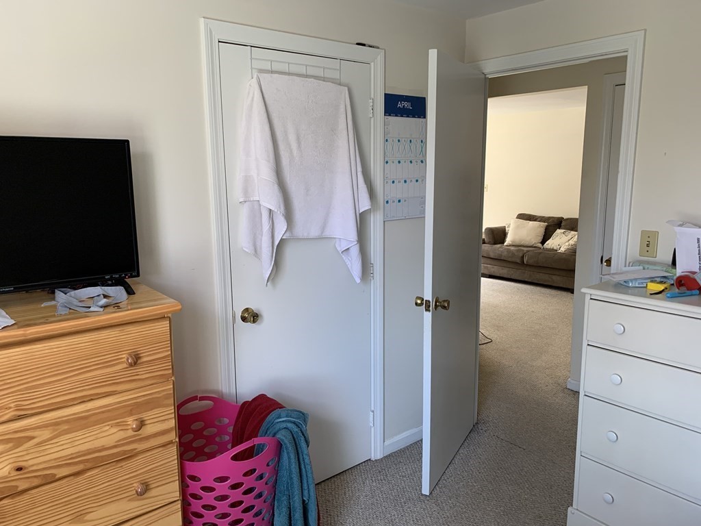 180 Tyngsboro Road, Unit 55D Chelmsford, MA 01863 - Photo 6 of 20 a hallway with a dresser and a flat screen tv