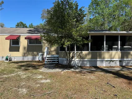 a view of a house with a yard and sitting area